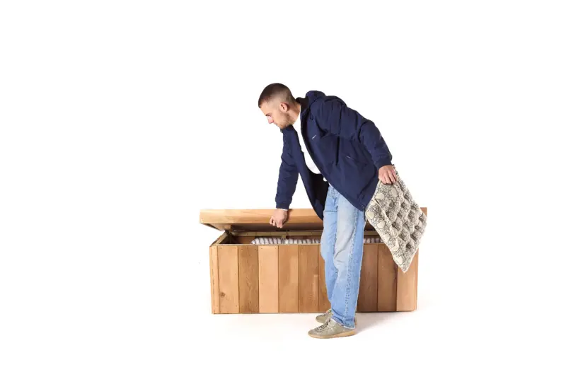 A man getting a cushion out of a waterproof garden storage bench